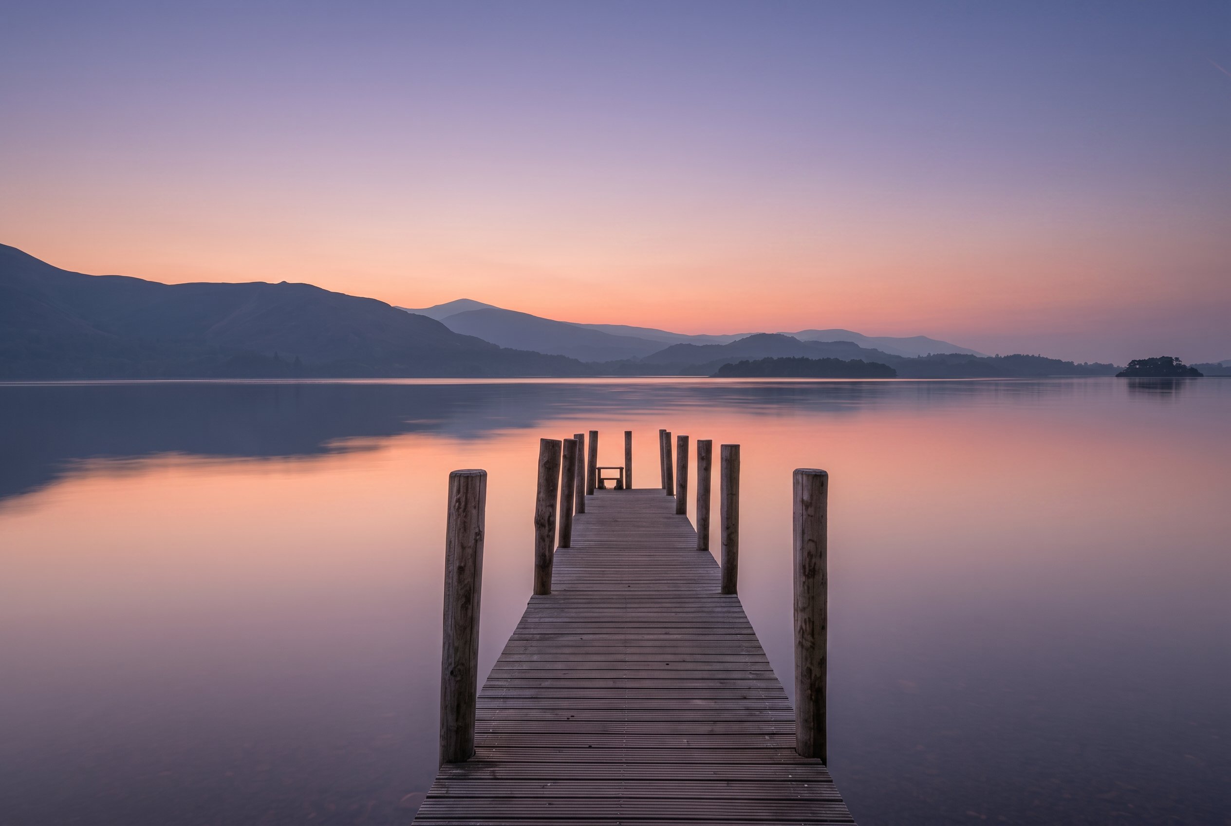 Jetty on a still lake at dusk